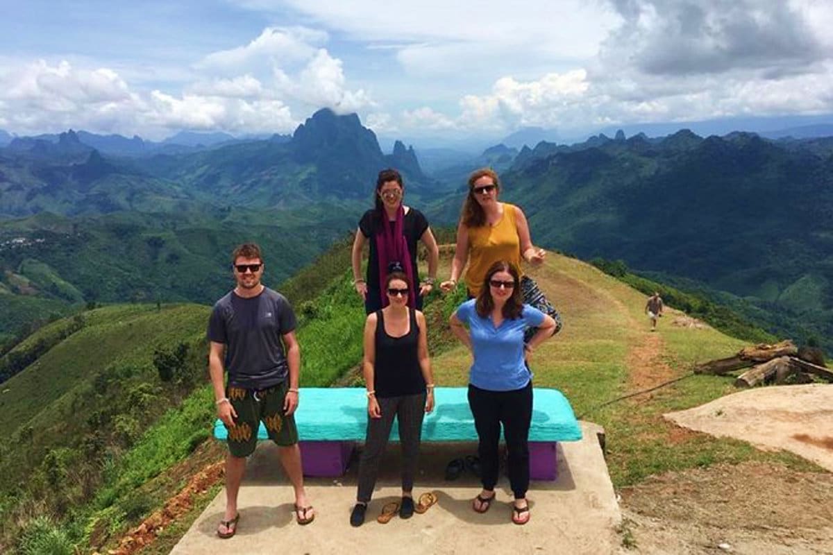 Sapa Half Day Trekking Tour Group of five tourists posing at scenic mountain viewpoint during Sapa half day trekking tour with dramatic limestone peaks a